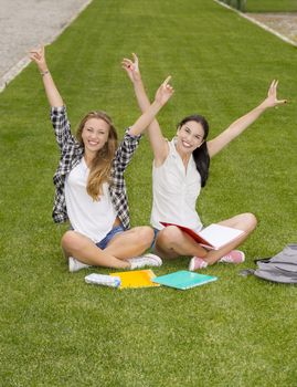 Happy best friends sitting on the grass and having a good time