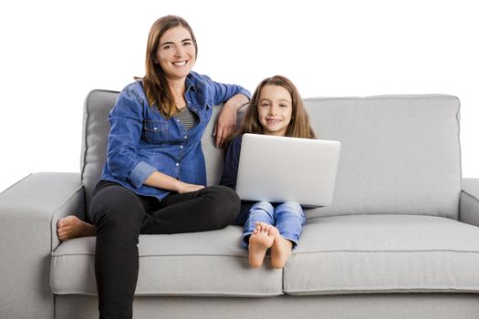 Mother teaching her little daughter working with a laptop