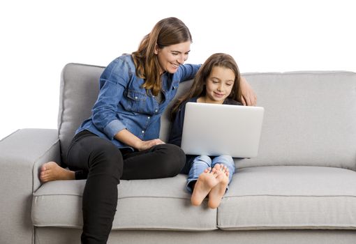 Mother teaching her little daughter working with a laptop