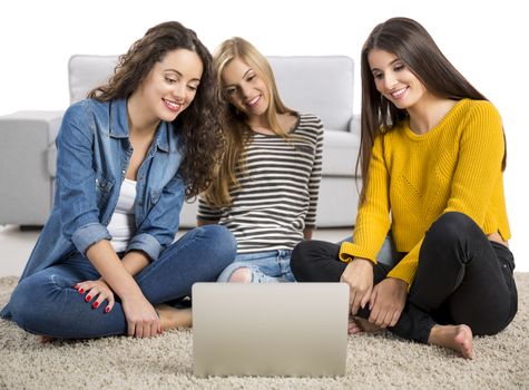 Happy teen girls studying at home with a laptop