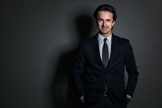 Portrait of businessman in suit on dark background