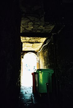 Garbage bins in gangway on a cobblestone street in Aberdeen