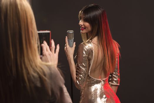 Fan photographing, with mobile phone, her favorite Pretty Woman Singer.