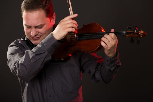 Close-up portrait of a young man playing the violin.