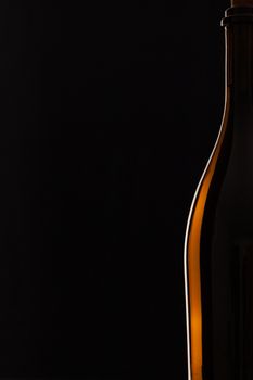 Detail of bottle with red wine on the black background