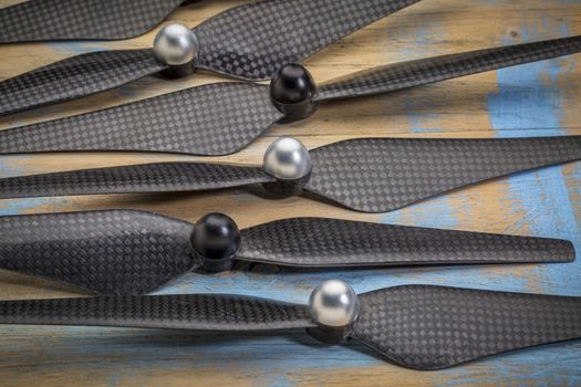 a set of carbon fiber propellers for a drone against grunge wood