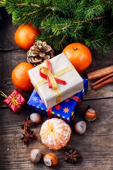 Christmas gifts,tangerines,nuts and spices on wooden background