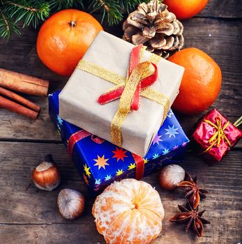 Christmas gifts,tangerines,nuts and spices on wooden background