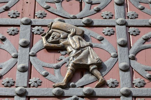 Porter  on the doors of the main entrance to Catalan Gothic church Santa Maria del Mar, Barcelona, Spain