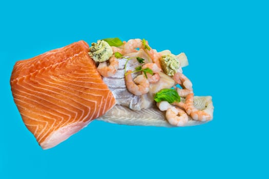Various raw fish species as fillets like salmon, cod and shrimp.