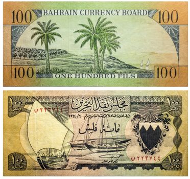 Banknote 100 fils Bahrain front and back isolated on white emitted on 1964. Dhow at left, arms at right. Back: Green and orange. Palm trees at center