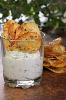 Fried potato chips with spicy sauce served in glass