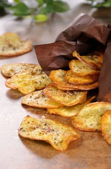 Fried potato chips scattered out of paper bags on the table