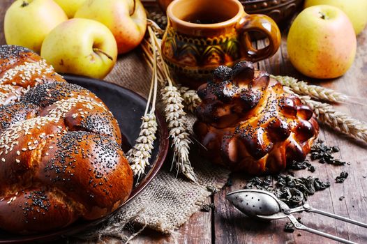 Autumn still life with scones,tea,apples and ears of wheat.