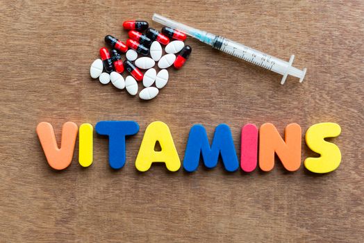 Vitamins colorful word in the wooden background