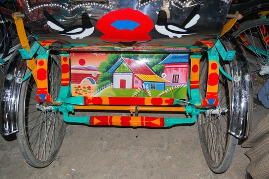 Dhaka, Bangladesh - May 9: The painters paint on back of tin sheet and frame of the rickshaw body. There are so many rickshaw painters in Bangladesh. This photo taken on May 9, 2014