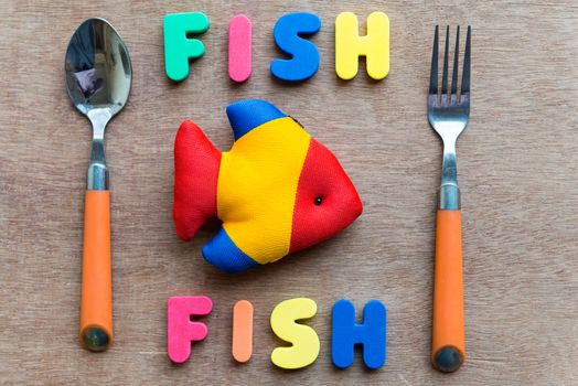fish fish with spoon colorful word on the wooden background