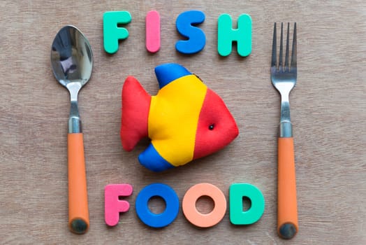 fish food with spoon colorful word on the wooden background