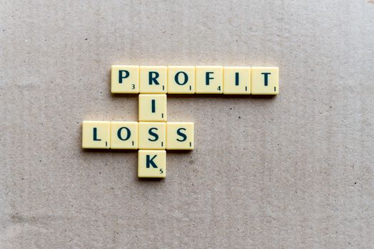 Profit, loss and risk crossword blocks on the wooden background
