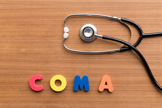 COMA colorful word on the wooden background