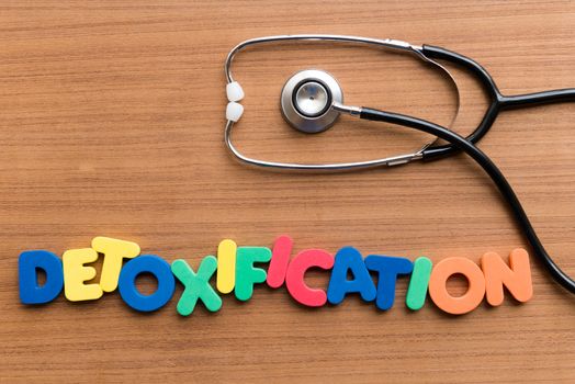 DETOXIFICATION colorful word on the wooden background