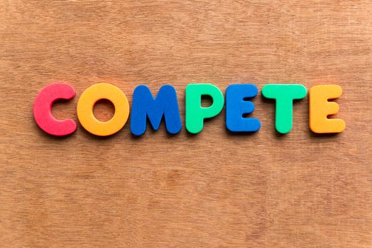 compete colorful word on the wooden background