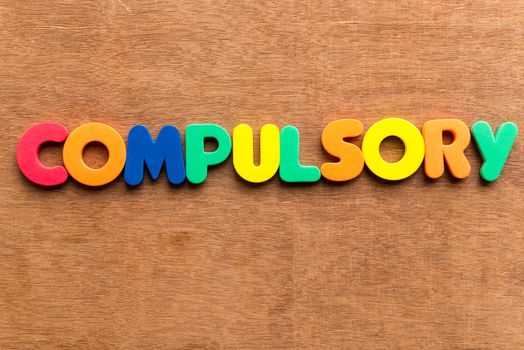 compulsory colorful word on the wooden background