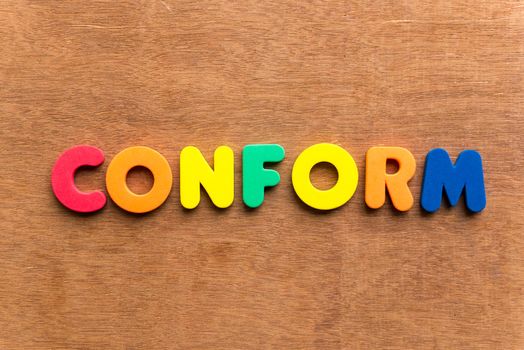 conform colorful word on the wooden background