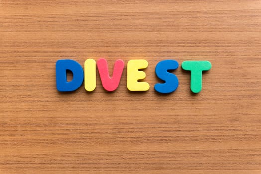 divest colorful word on the wooden background