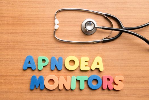 Apnoea monitors colorful word with stethoscope on the wooden background