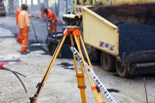 Survey equipment at asphalting works. Road construction and repairing works.