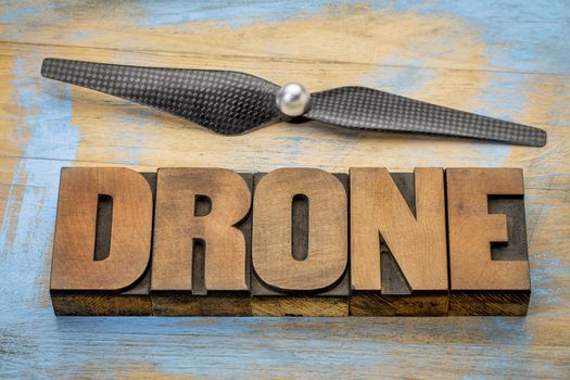 drone word abstract in vintage letterpress  wood type with a drone propeller