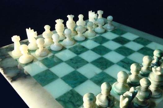 chessboard and alabaster chess on a black background