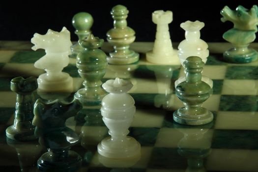 chessboard and alabaster chess on a black background