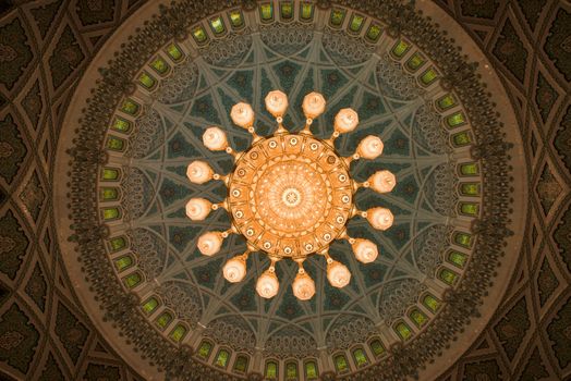 Muscat, Oman - February 28, 2016: The chandelier and inside of the dome of Sultan Qaboos Grand Mosque in Muscat, Oman. This is the largest and most decorated mosque in this mostly Muslim country.