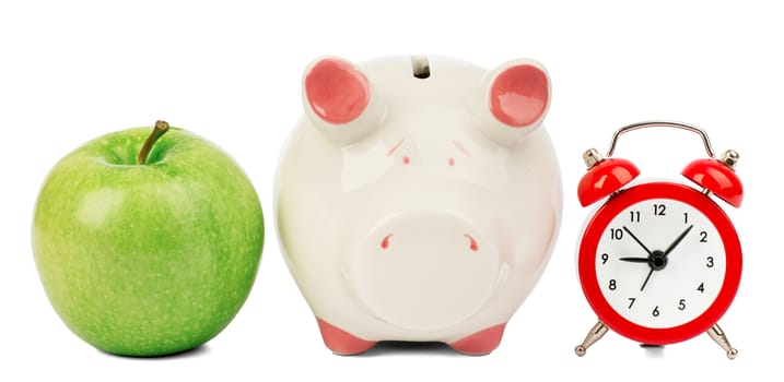 Green apple with alarm clock and piggy bank on isolated white background