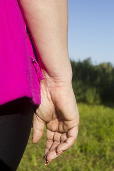 Hand of a young woman in tracksuit outdoors
