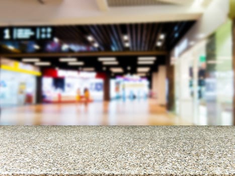 Marble board empty table in front of blurred background. Perspective marble table over blur in shopping mall hall. Mock up for display or montage your product.