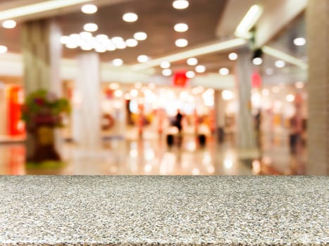 Marble board empty table in front of blurred background. Perspective marble table over blur in shopping mall hall. Mock up for display or montage your product.