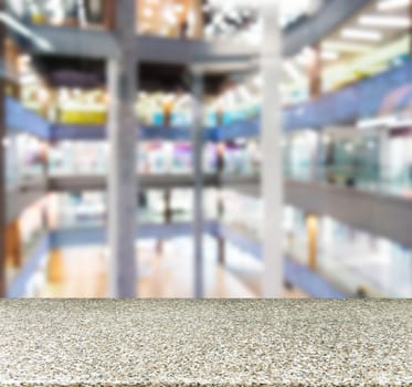 Marble board empty table in front of blurred background. Perspective marble table over blur in shopping mall hall. Mock up for display or montage your product.