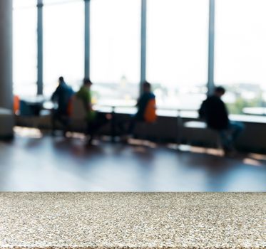 Marble board empty table in front of blurred background. Perspective marble table over blur silhouettes of people sitting in a cafe.. Mock up for display or montage your product.