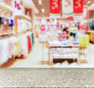 Marble board empty table in front of blurred background. Perspective marble table over blur in kids wear of departament store. Mock up for display or montage your product.