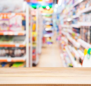 Wooden board empty table in front of blurred background. Perspective light wood table over blur in kids toy store. Mock up for display or montage your product.