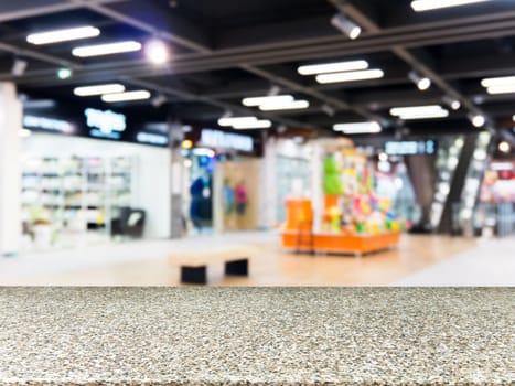 Marble board empty table in front of blurred background. Perspective marble table over blur in shopping mall hall. Mock up for display or montage your product.