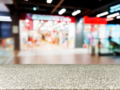 Marble board empty table in front of blurred background. Perspective marble table over blur in shopping mall hall. Mock up for display or montage your product.