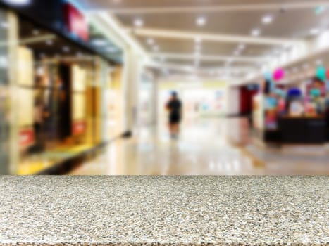 Marble board empty table in front of blurred background. Perspective marble table over blur in shopping mall hall. Mock up for display or montage your product.