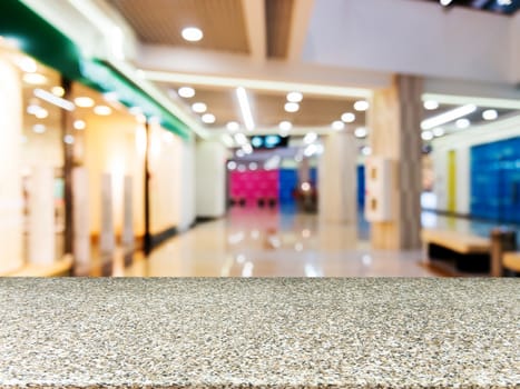 Marble board empty table in front of blurred background. Perspective marble table over blur in shopping mall hall. Mock up for display or montage your product.