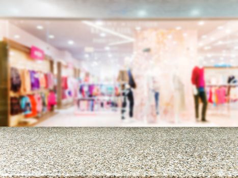 Marble board empty table in front of blurred background. Perspective marble table over blur in dress store. Mock up for display or montage your product.