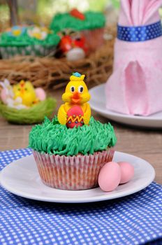 Muffin decorated Easter chicken sitting on the grass