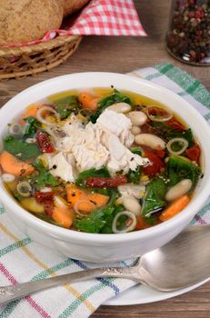 chicken soup with beans, spinach, tomatoes and other vegetables